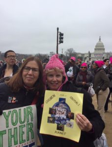 Two women holding up a sign and a picture.