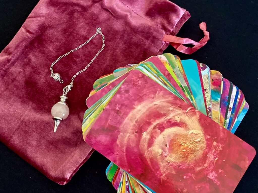 The Divine Pendulum Oracle deck with cards, pendulum, and velvet bag